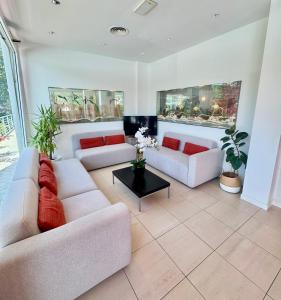 a living room with two couches and a table at Hotel San Francisco in Lignano Sabbiadoro