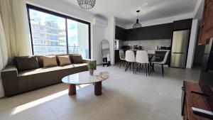 a living room with a couch and a table at Spacious & Modern - Best Larnaca Location in Larnaca