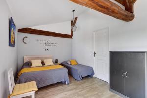 a bedroom with two beds and a flat screen tv at Chambre d'Hote Familiale in Neuville-du-Poitou +19 photos