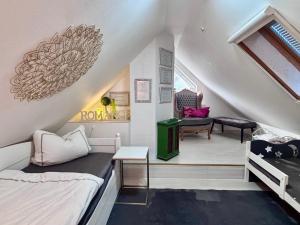 a attic room with a bed and a chair at Quartier Sängerstadt in Finsterwalde