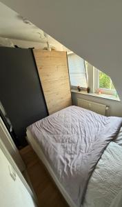 a small bedroom with a bed and a window at Modernes gemütliches Studio Zimmer in Elmshorn