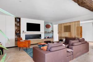 a living room with two couches and a flat screen tv at Chambre d'Hote Familiale in Neuville-du-Poitou