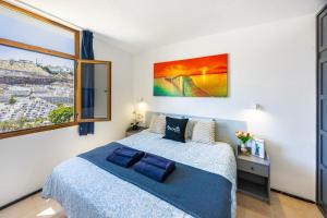a bedroom with a bed and a large window at Modern Sea View Apartment Near Beach & Pool Puerto Rico in Puerto Rico de Gran Canaria