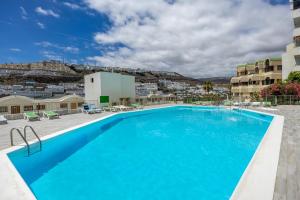 a pool at a hotel with a view at Modern Sea View Apartment Near Beach & Pool Puerto Rico in Puerto Rico de Gran Canaria