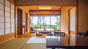 a dining room with a table and a large window at Isaribi (No Children) in Higashiizu