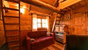 a living room with a red couch in a cabin at Uneallika hubane saunaga majake "Hoburaud" in Pae