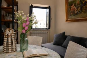 a vase of flowers on a table with a book at Villetta Incanto relax in Cava deʼ Tirreni