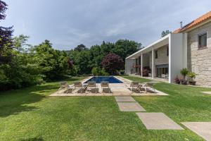 a yard with chairs and a swimming pool at Quinta Trindade in Arouca