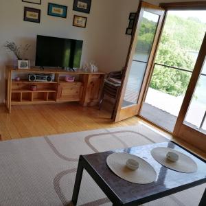 a living room with a tv and a table at Apartman Ružica in Banja