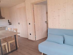 a living room with a blue couch and a table at écolodge Calendula in Leimbach