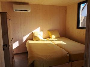 a bedroom with a bed with yellow pillows and a window at écolodge Calendula in Leimbach