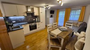 a kitchen and living room with a table and a dining room at Der Perweinhof in Donnersbachwald