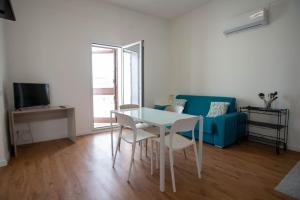 a living room with a table and a blue couch at Da Jaco in Castellammare del Golfo