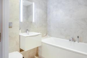 a white bathroom with a tub and a sink at 2 Bed in Sandown oc-90013 in Sandown +23 photos