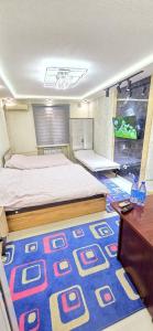 a bedroom with a bed and a blue rug at ARZON Halal Hotel in Tashkent