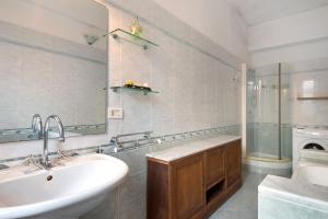 a bathroom with a sink and a mirror and a tub at Via Daneri 2 con giardino in Bonassola +22 photos