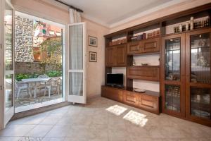 a kitchen with wooden cabinets and a balcony with a table at Via Daneri 2 con giardino in Bonassola
