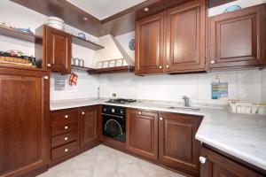 a kitchen with wooden cabinets and a stove top oven at Via Daneri 2 con giardino in Bonassola
