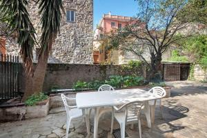 a white table and chairs in front of a building at Via Daneri 2 con giardino in Bonassola