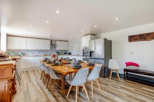 a kitchen with a wooden table and white cabinets at 6 Bed in Holsworthy oc-89218 in Merryfield