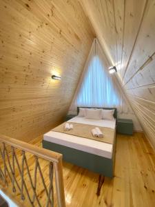 a bed in a room with a wooden ceiling at Cozy Cottage Martvili in Martvili