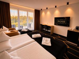 a hotel room with two beds and a tv at Villa Posh All Suites Hotel & SPA in Międzywodzie +63 photos