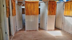 a hallway with white doors and a tile floor at Islas de San blas Glamping in Tubusinica