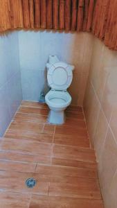 a toilet in a bathroom with a wooden floor at Islas de San blas Glamping in Tubusinica