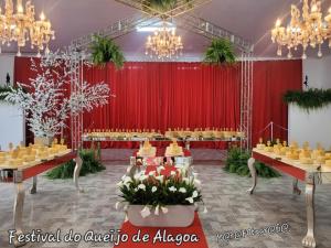 a banquet hall with a red curtain and tables with cakes at Studio Mara Alagoa in Alagoa