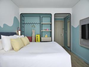 a bedroom with a large white bed and a tv at ibis Styles Vung Tau in Vung Tau
