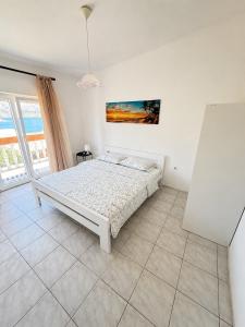 a bedroom with a bed and a painting on the wall at Apartmani Leona in Metajna