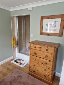 a bedroom with a wooden dresser and a shower at The Stables Annexe in Patrington