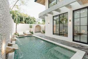 an infinity pool in the backyard of a house at Casa Amore 4BR Seminyak in Seminyak