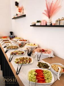a buffet with many plates of food on a table at Villa Posh All Suites Hotel & SPA in Międzywodzie