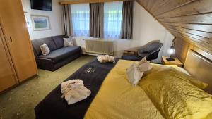 a bedroom with a large bed and a couch at Der Perweinhof in Donnersbachwald