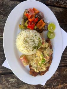 a plate of food with rice and vegetables on a table at Islas de San blas Glamping in Tubusinica