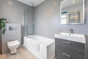 a bathroom with a tub and a toilet and a sink at 2 Bed in Croyde oc-18lead in Croyde +15 photos