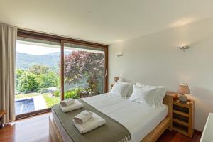 a bedroom with a bed and a large window at Quinta Trindade in Arouca +99 photos