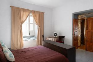 a bedroom with a bed and a window with a desk at Zaks House Valle San Lorenzo in Arona