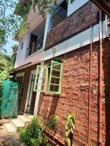 a brick building with a green window on it at Casa Viora in Calangute