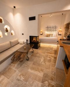 a living room with a couch and a fireplace and a bed at Adyton Guest House in Didim