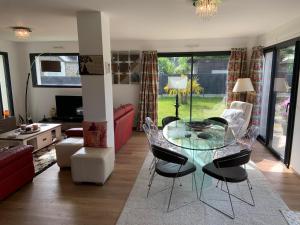 a living room with a glass table and chairs at Le Clos Carnonen, villa avec piscine in Quessoy