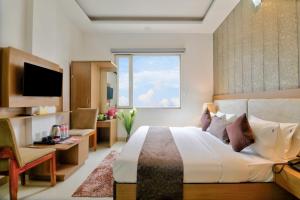 a bedroom with a large bed and a window at Hotel Olive Aero Suites By Signature Stayz Near Delhi Airport in New Delhi