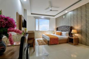 a hotel room with a bed and a desk at Hotel Olive Aero Suites By Signature Stayz Near Delhi Airport in New Delhi +36 photos