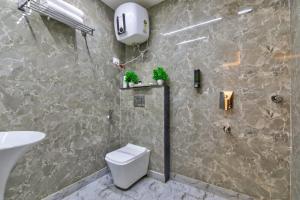 a bathroom with a shower and a toilet and a sink at Hotel Olive Aero Suites By Signature Stayz Near Delhi Airport in New Delhi