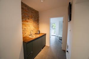 a bathroom with a sink and a brick wall at Villa-Vista di Pini Sarajevo in Sarajevo
