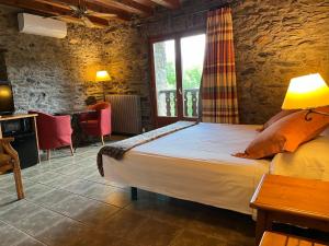 a bedroom with a bed and a table and a window at Mas D'en Roqueta in Aravell +71 photos