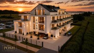 an aerial view of a building with the sunset in the background at Villa Posh All Suites Hotel & SPA in Międzywodzie