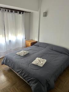 a bedroom with a bed with two towels on it at Hanna in Mar del Plata