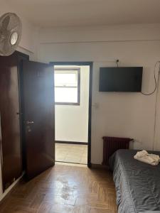 a room with a bed and a door with a television at Hanna in Mar del Plata